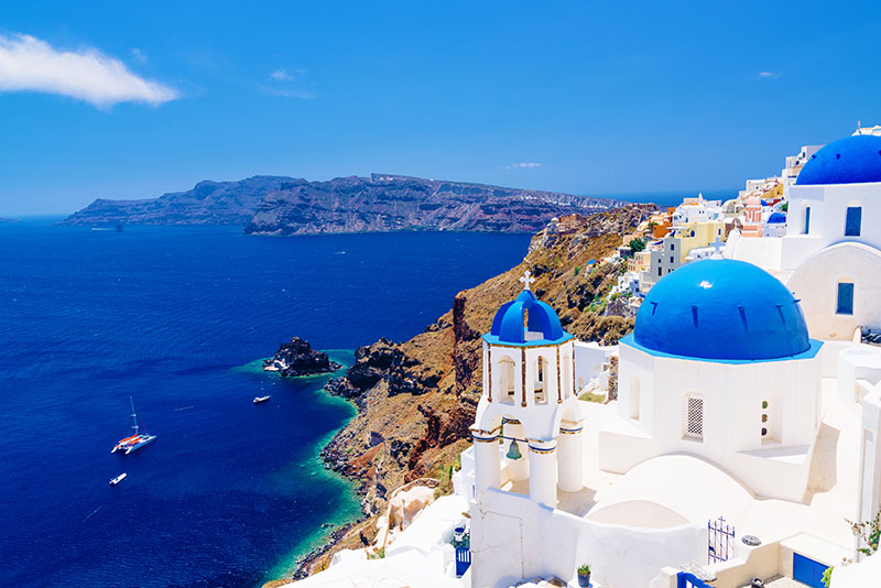 White architecture and churches with blue domes Oia Santorini Greece