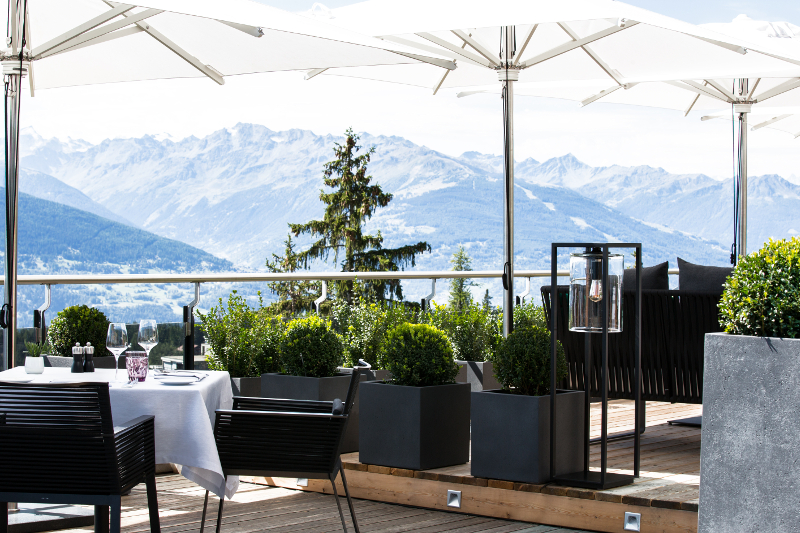 An outside eating area with the Alps in the background