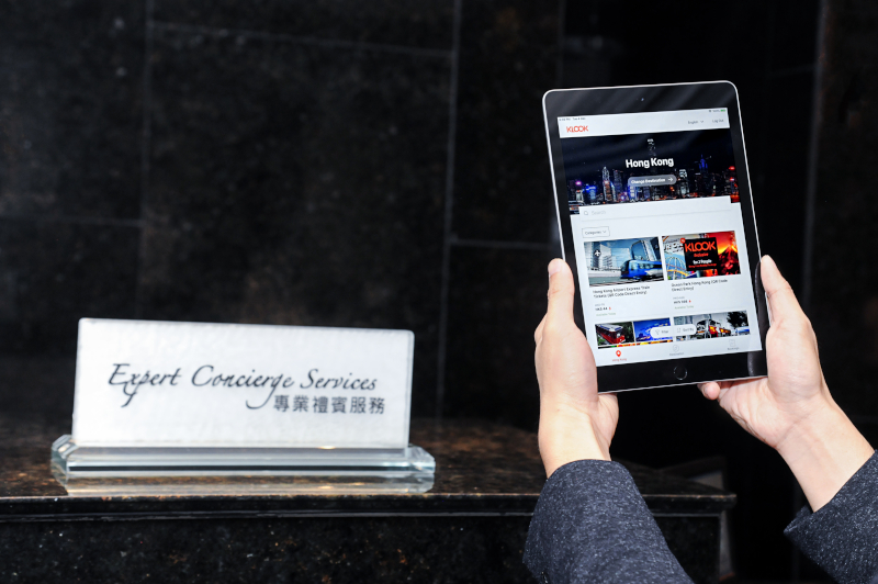 A tablet with Klook open sits in front of a concierge desk