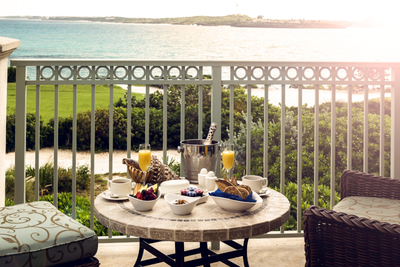 A breakfast is laid on a balcony facing the water
