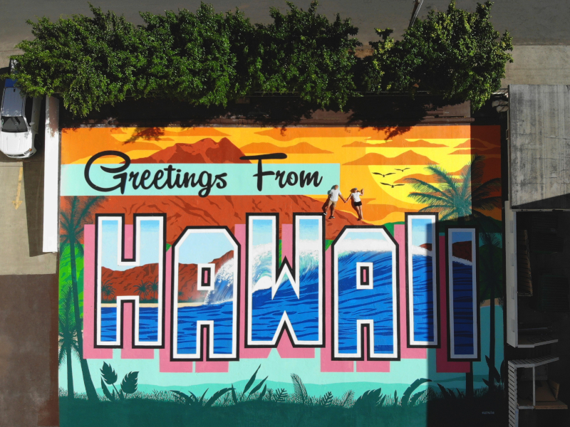 Two people lay out on the new Greetings From Hawaii mural