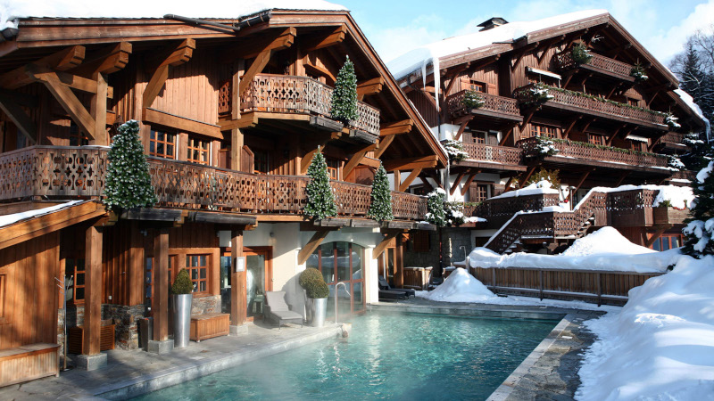 Image of hotel with outdoor pool surrounded by snow 