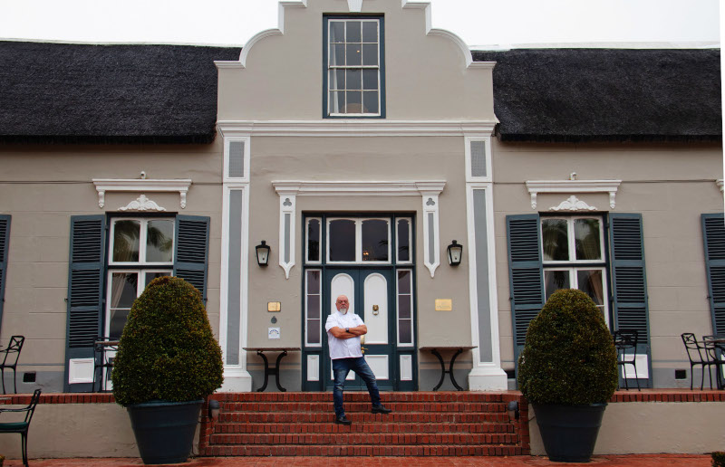 Image of chef standing in front of hotel 