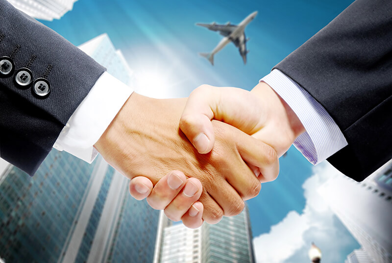 handshake with airplane in background