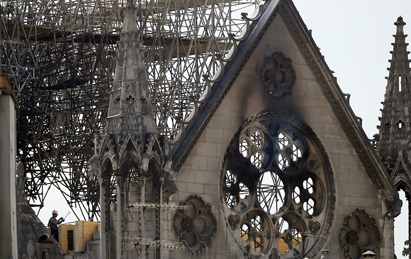 A worker checks on a wooden support structure placed on the Notre Dame Cathedral in Paris