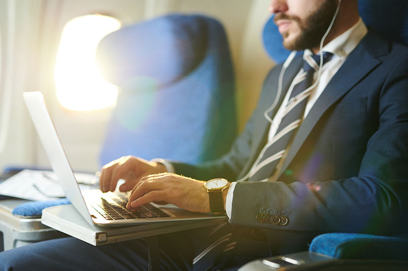 man on laptop on airplane