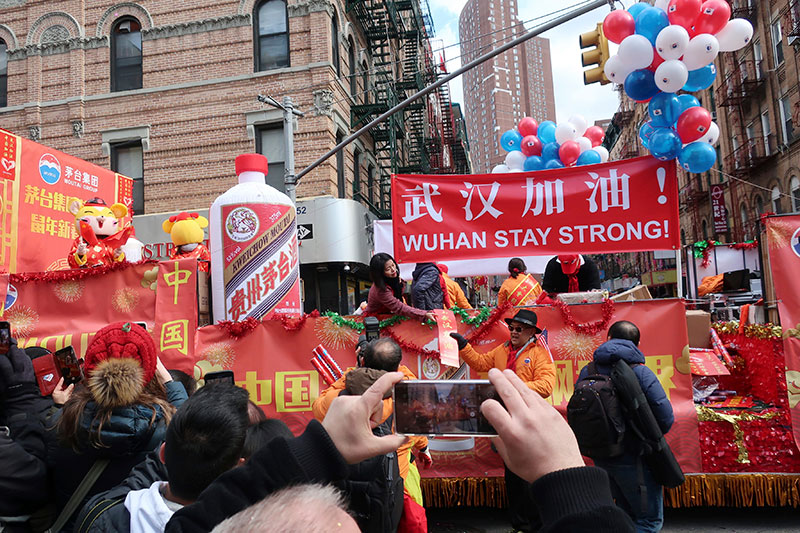 People display signs in support of Wuhan China at the center of the coronavirus outbreak during the Lunar New Year parade