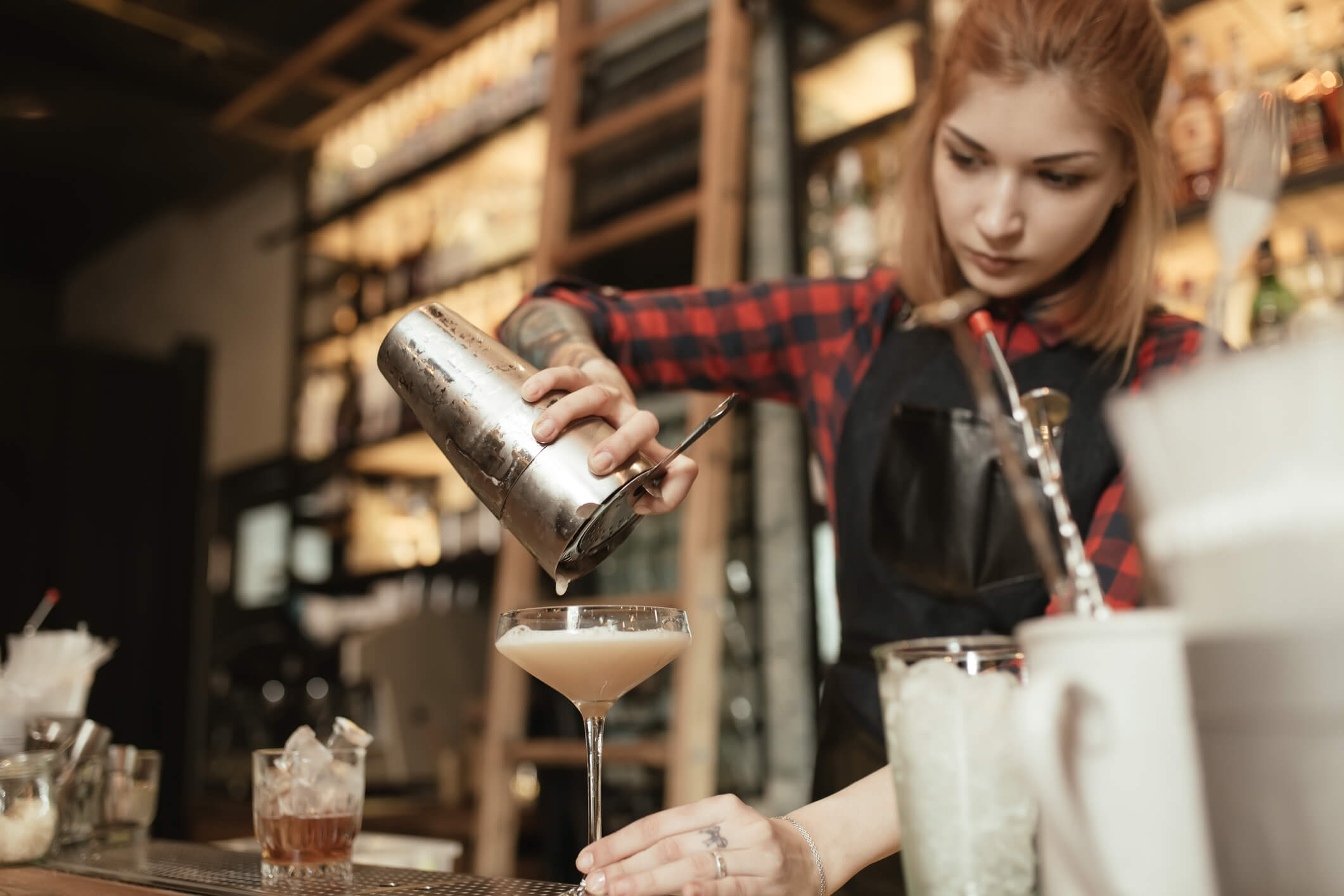 Female bartender pouring a cocktail