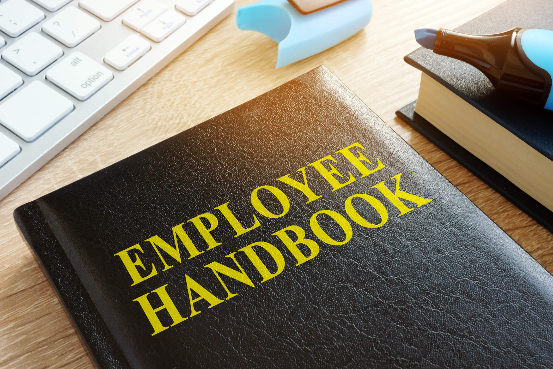 Black employee handbook and blue highlighter