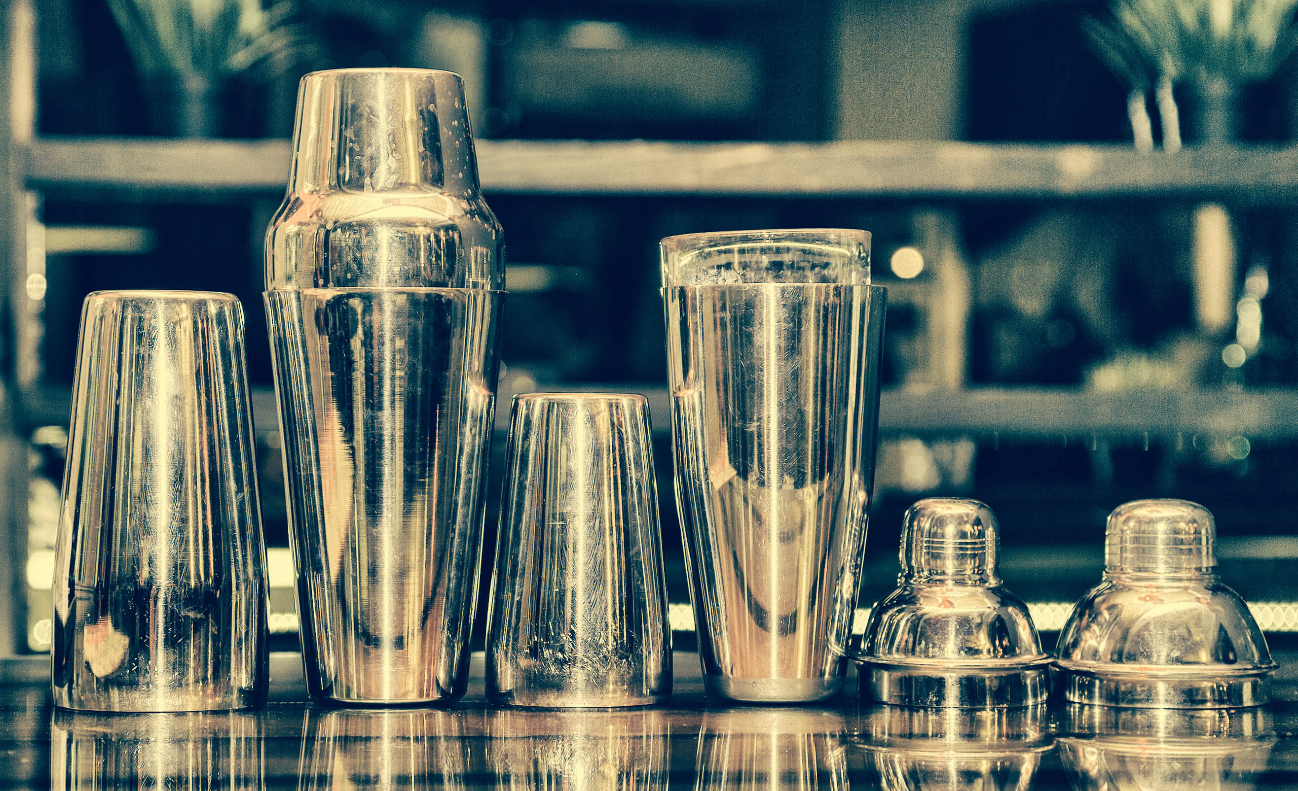 Stainless steel cocktail shakers on a bar