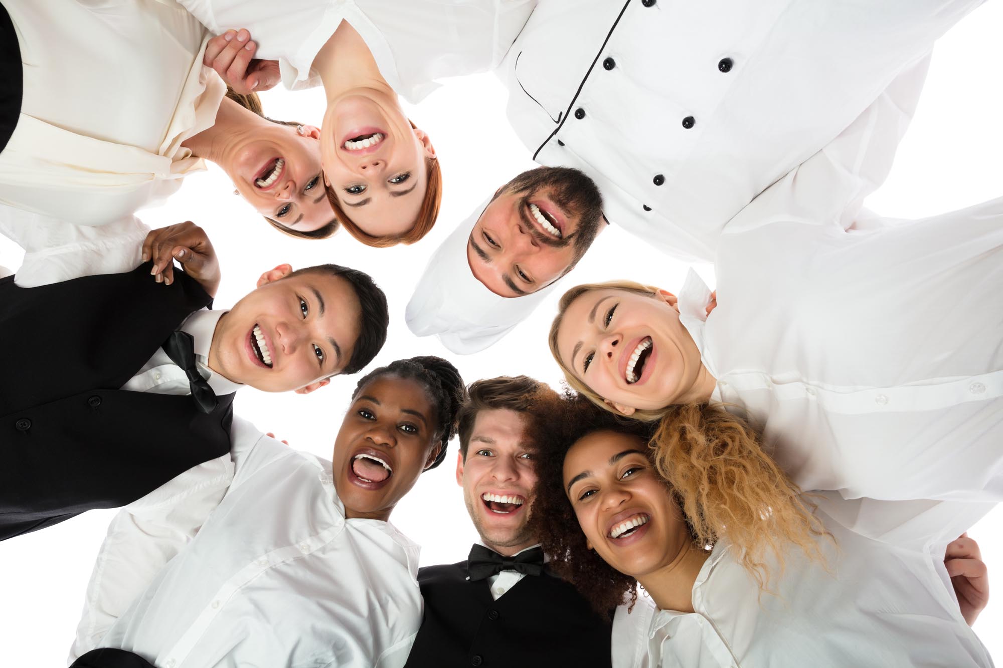 Smiling restaurant staff standing in circle against white background