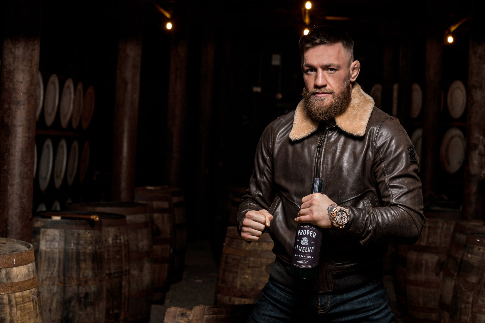 Conor McGregor holding a bottle of Proper No 12 Irish Whiskey