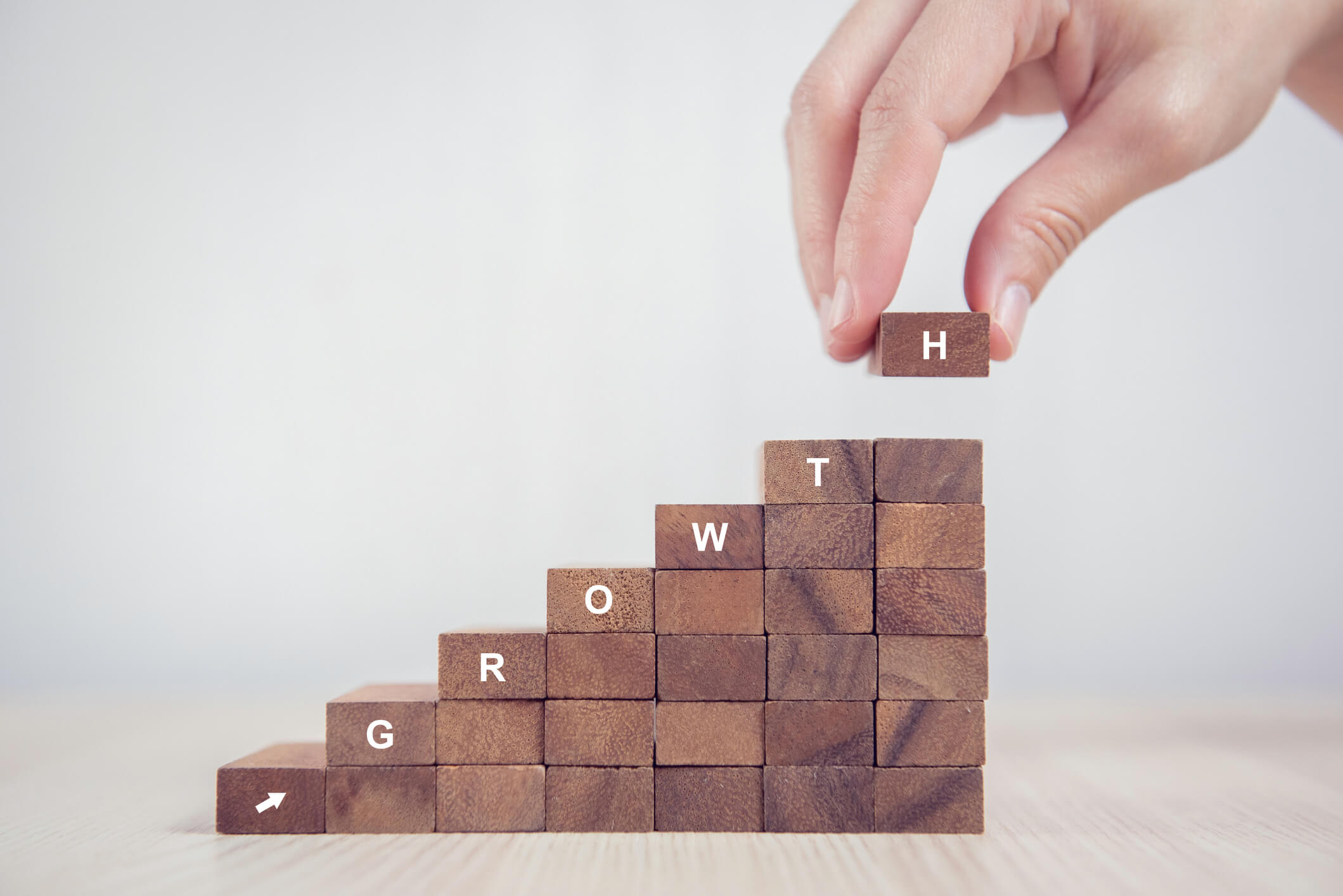 Blocks being stacked spelling the word growth