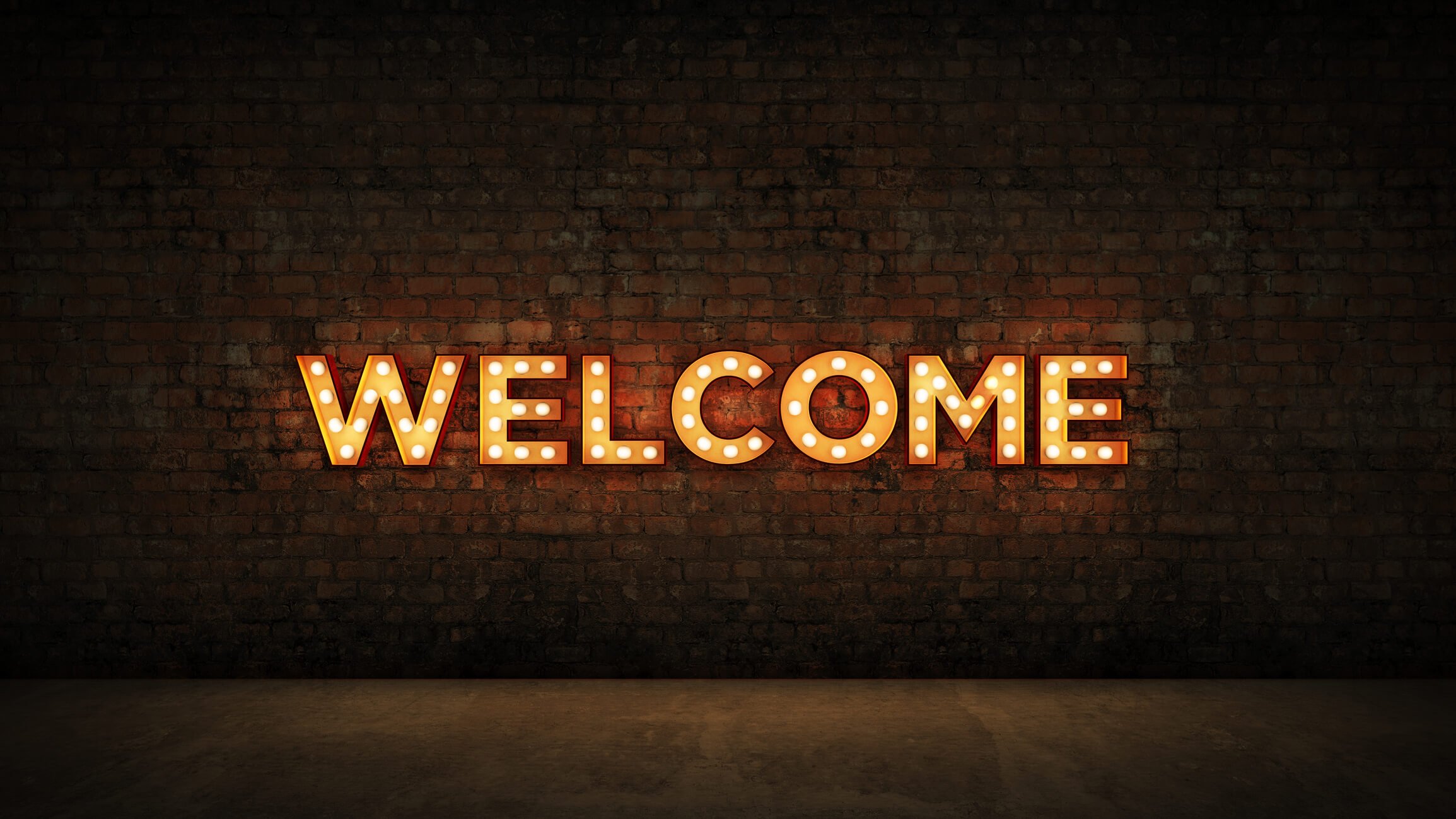 Neon Welcome sign on brick wall