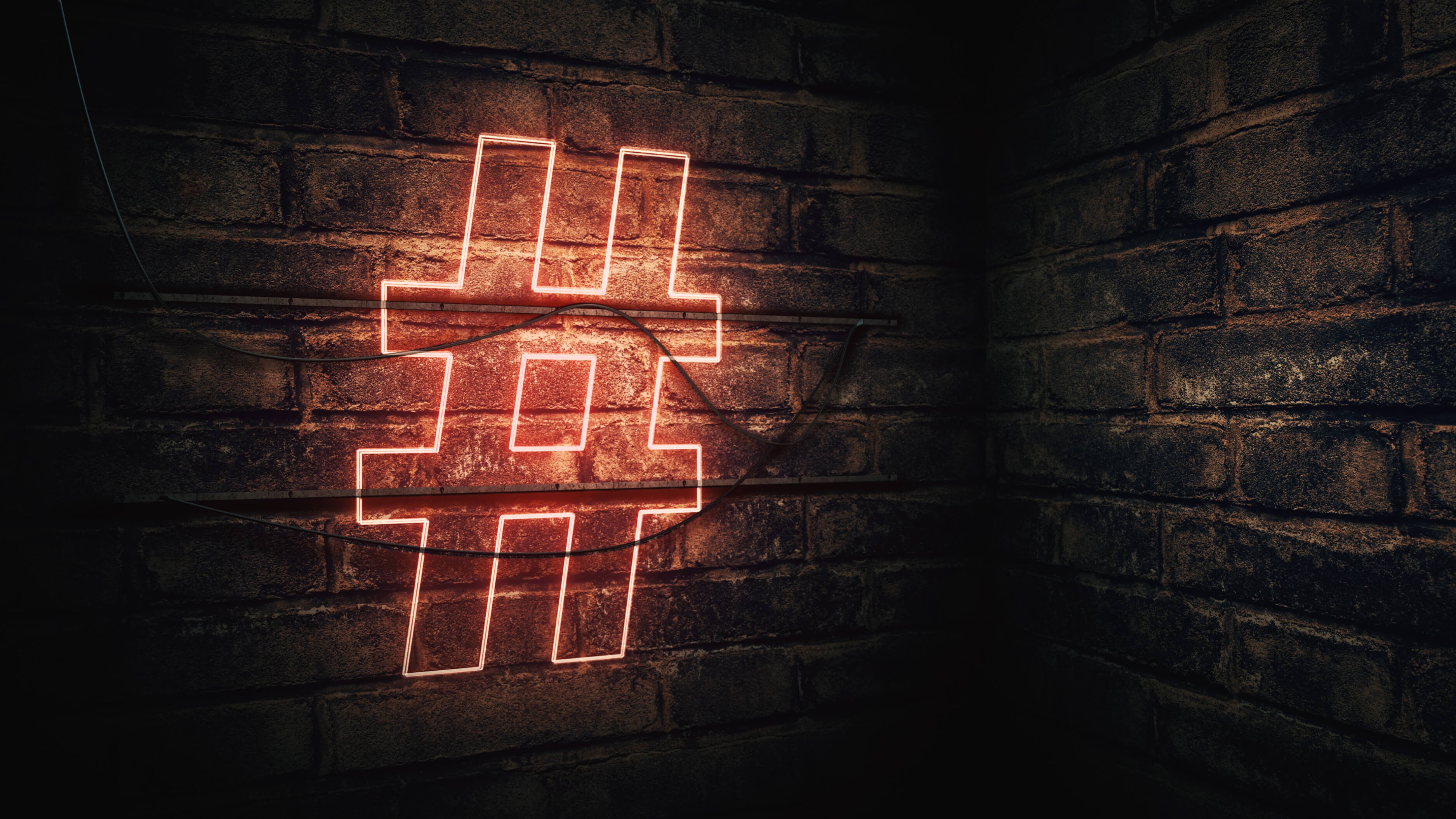Neon hashtag sign on brick wall