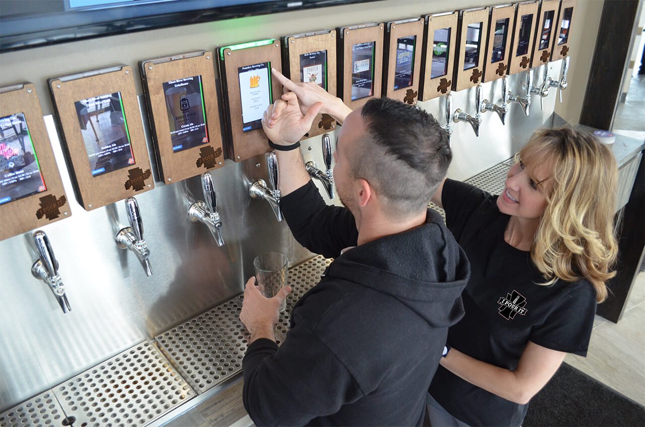 IPourIt rep helping customer with pour-your-own beer system at Pizza Rev