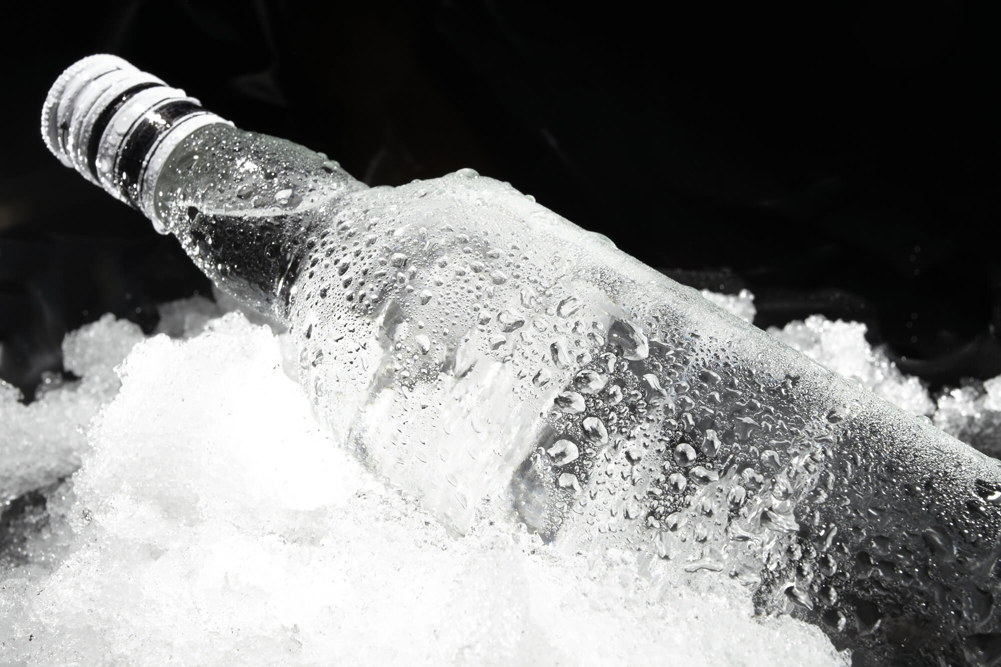 Bottle of clear liquor on ice
