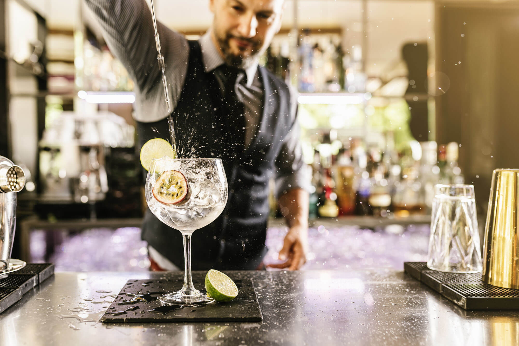 Bartender pouring a drink and splashing the bar