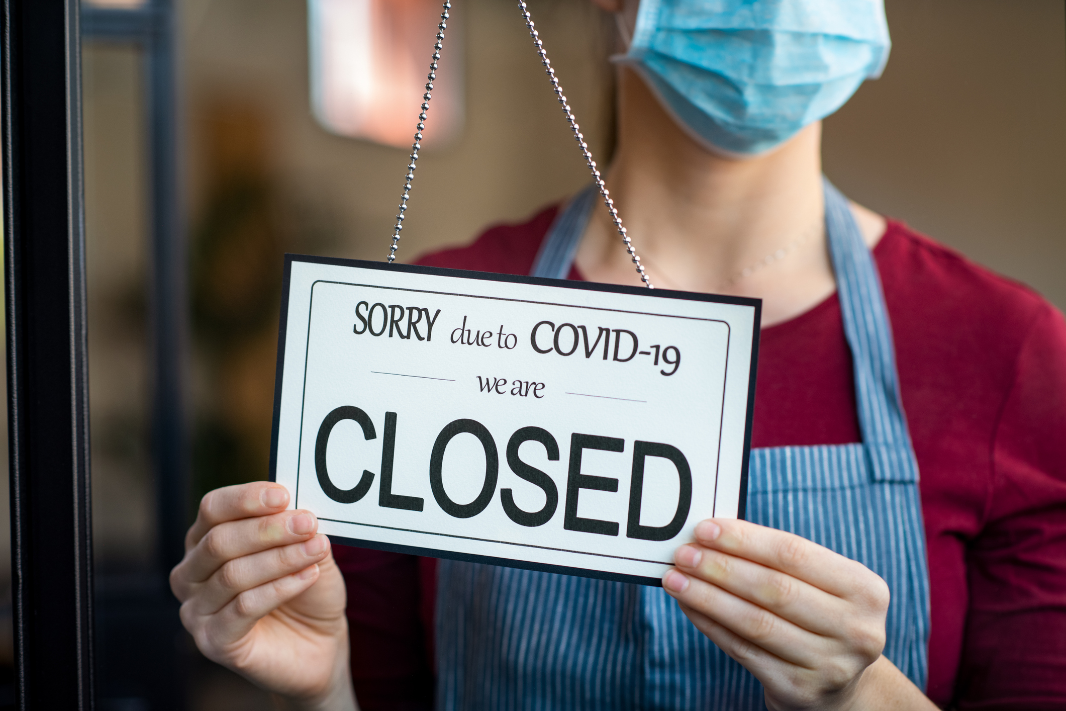 Restaurant owner wearing surgical mask closes her restaurant due to quarantine and coronavirus