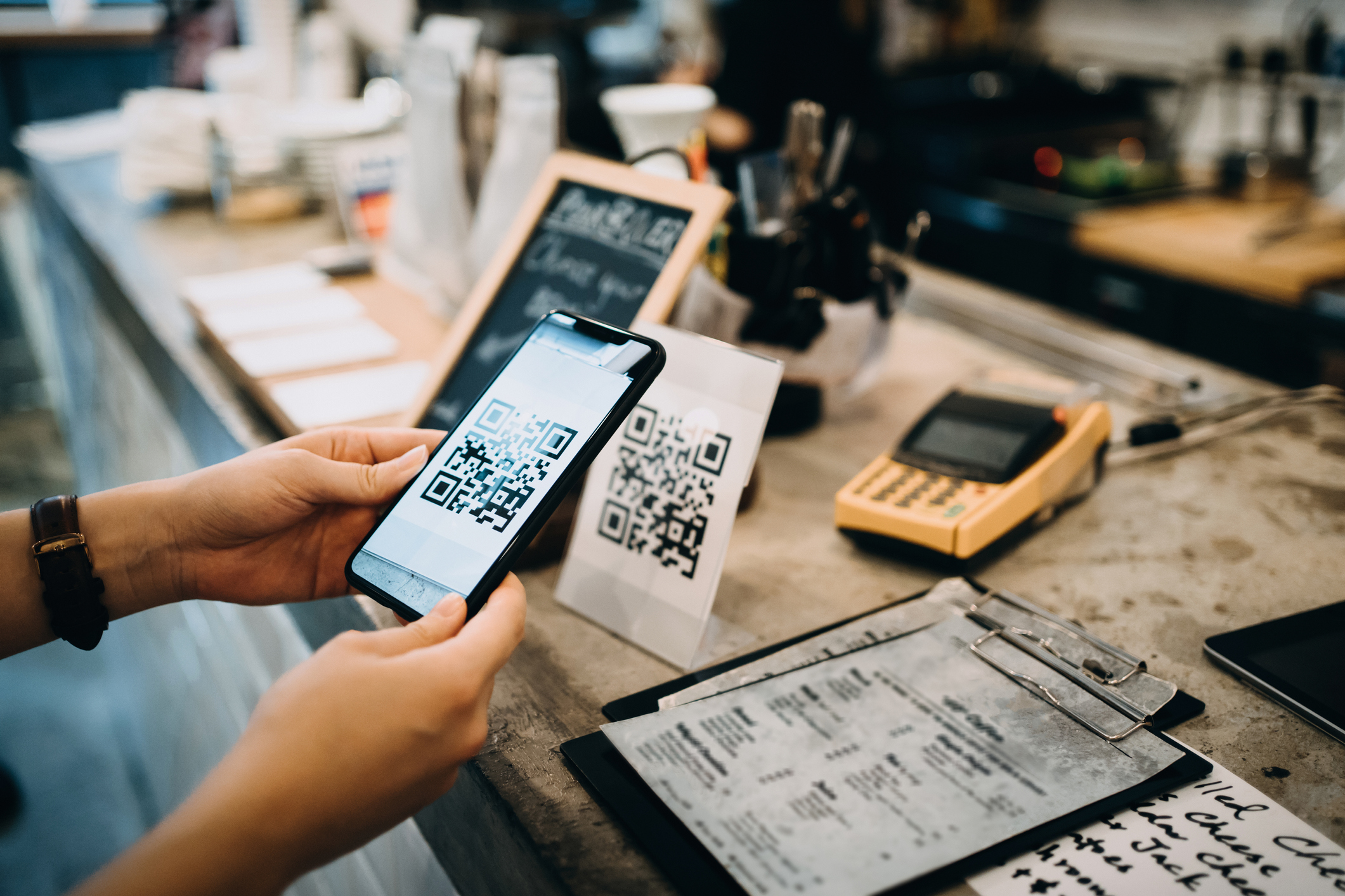 A customer scans a QR code at a restaurant for easy contactless payment 