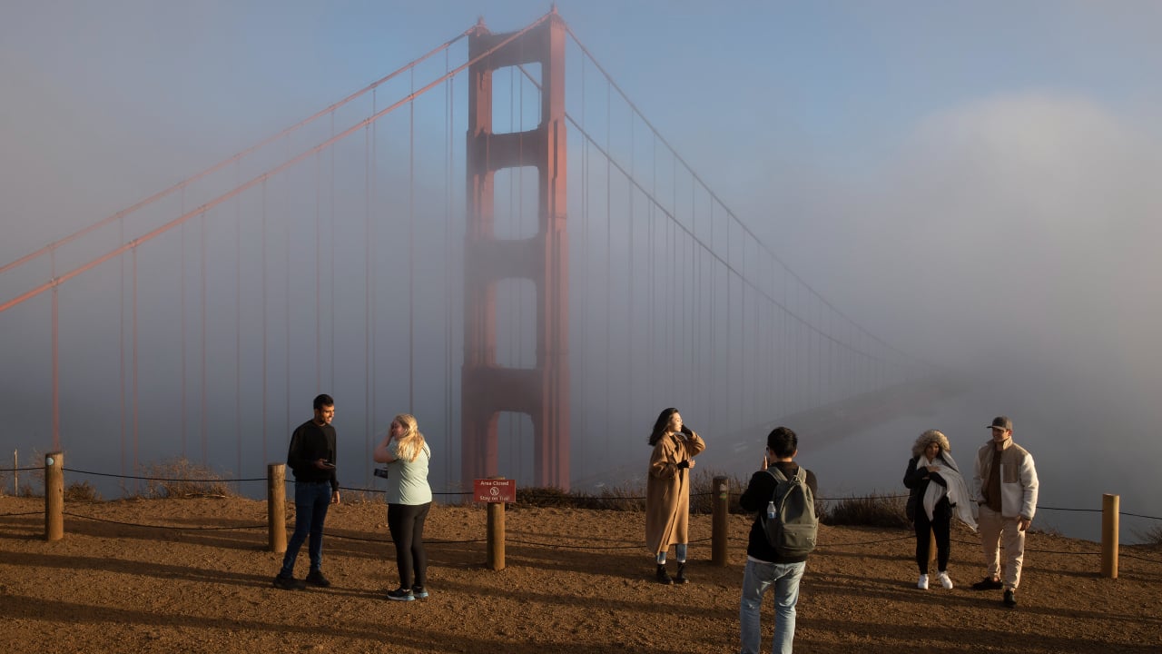 Tourists visit the cloud-shrouded Golden Gate Bridge on November 4 2023 in San Francisco California