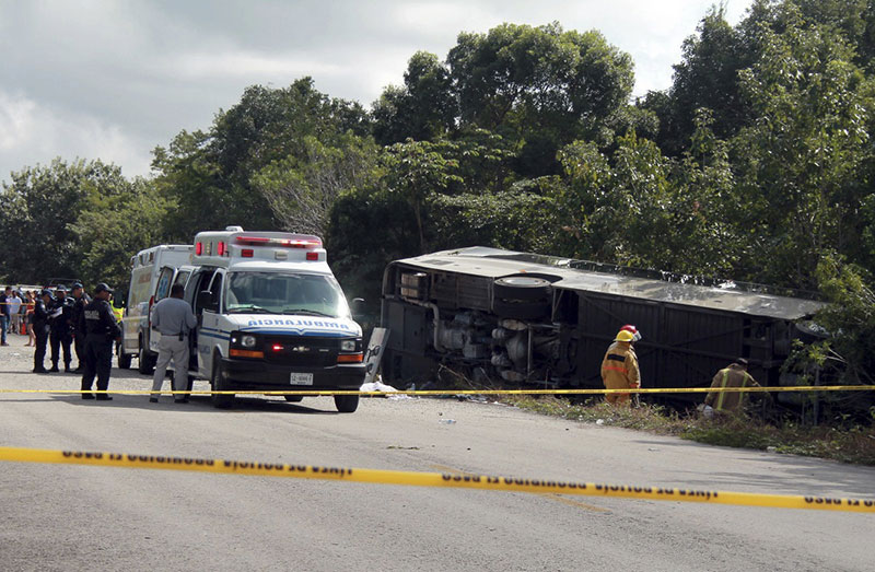 An ambulance sits parked next to an overturned bus in Mahahual Quintana Roo state Mexico