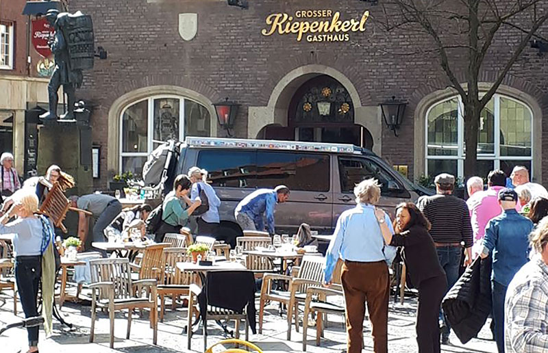 People stay in front of a restaurant in Muenster Germany after a vehicle crashed into a crowd