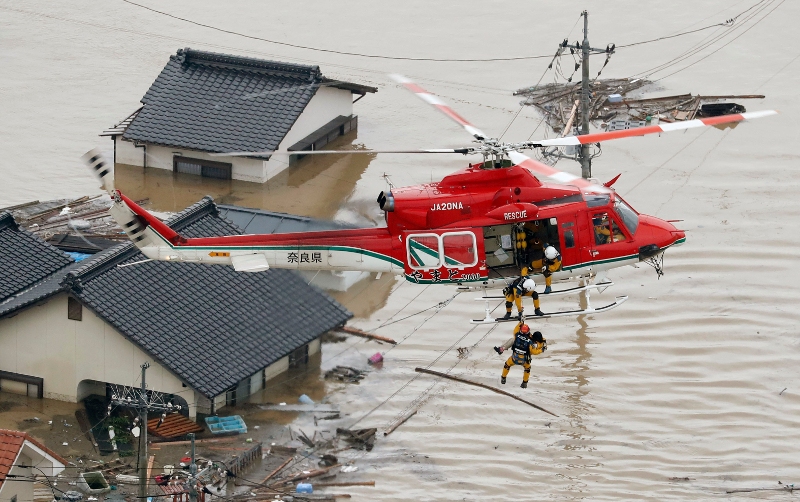 A resident is rescued in a flooded area in Kurashiki Okayama prefecture following heavy rains