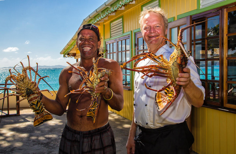 Image of chef holding a lobster by the sea 