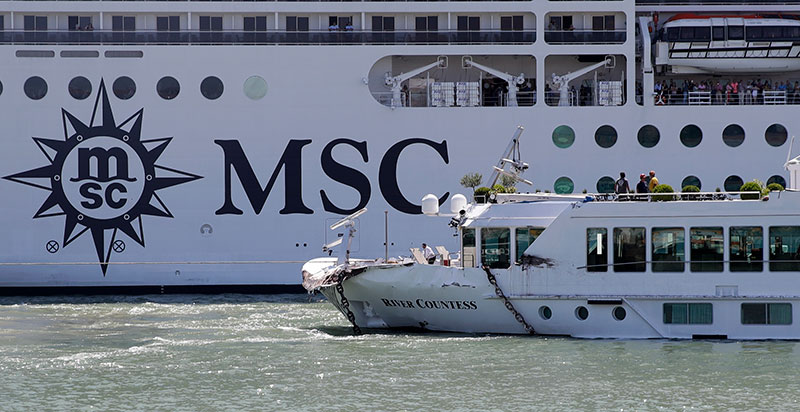 The MSC Magnifica cruise ship passes by the tourist boat foreground bottom right that was struck by a towering cruiser fo