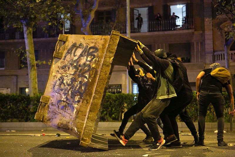 Protestors make barricades in the street during clashes with police in Barcelona