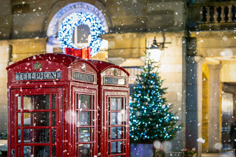 Red telephone booths in front of Christmas decorations lights in London United Kingdom