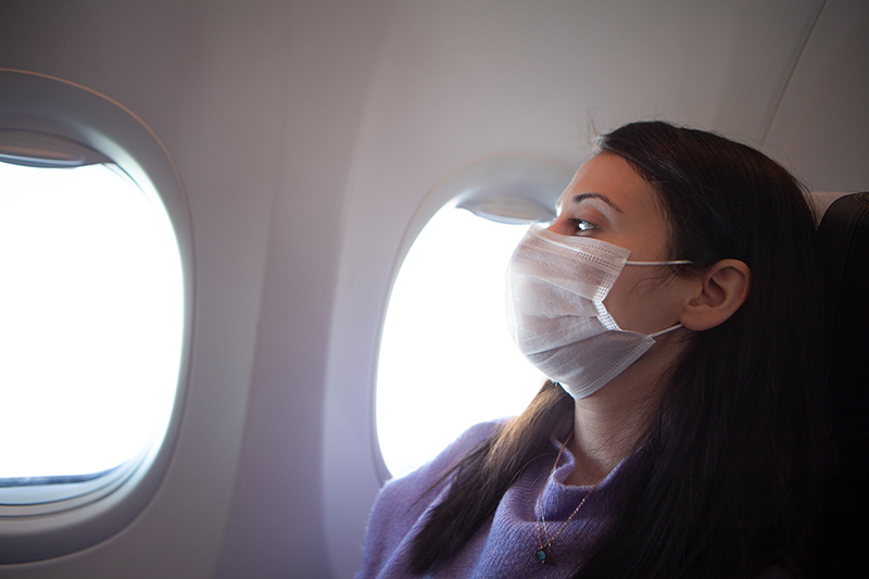 woman with a mask on a plane