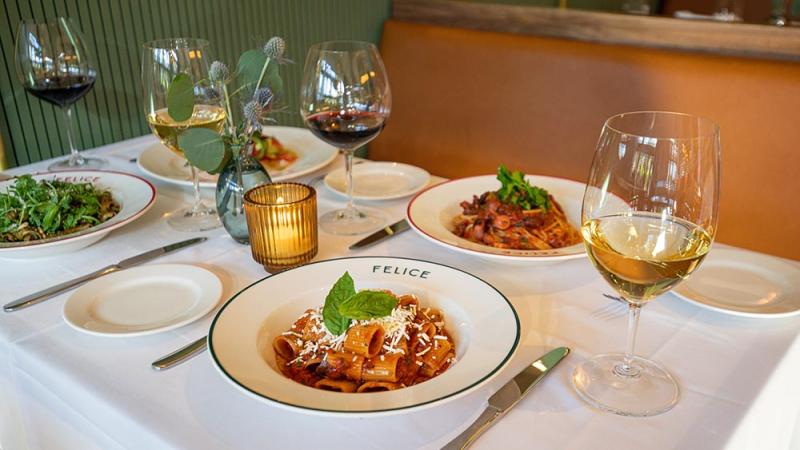 A table for four with pasta and wine served