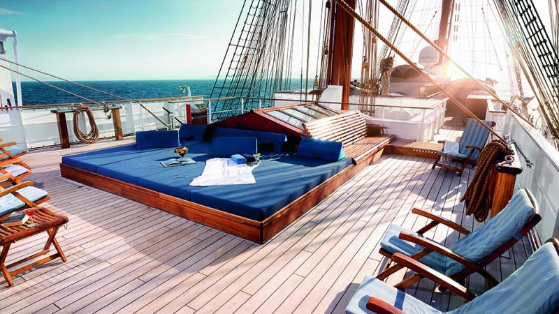 Blue sunbeds on the top deck of a sailing ship