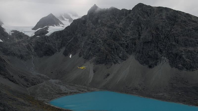 A helicopter flying over a blue lake in Norway