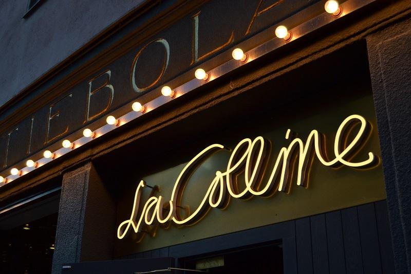 An illuminated restaurant sign reads La Colline 