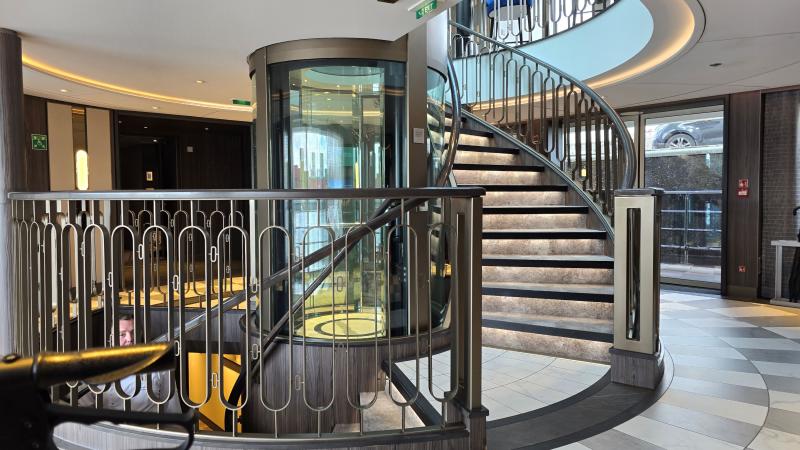 The atrium of Riverside Luxury Cruises' Riverside Debussy has a central design element of a small glass elevator and a circular staircase.