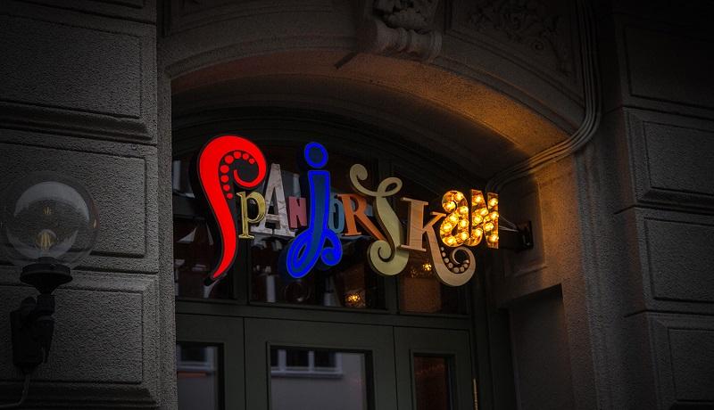 An illuminated restaurant sign reads Spanjorskan