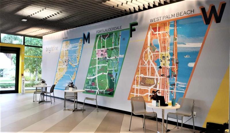 The ground level of Brightline's Fort Lauderdale station has ticket machines, a check-in counter and passengers tables with several South Florida station maps on the wall.