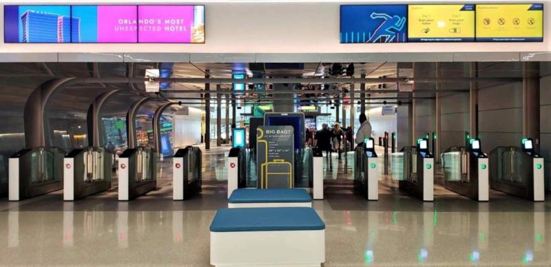 Train riders scan their QR code tickets to enter the terminal waiting area for Brightline at Orlando International Airport.