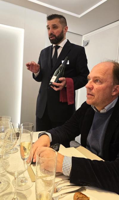 A sommelier from Riverside Debussy explains the fine wines that will be served in the Vintage Room experience. Table mate Gregor Gerlach, co-owner and chairman, Riverside Luxury Cruises and The Seaside Collection is shown seated.