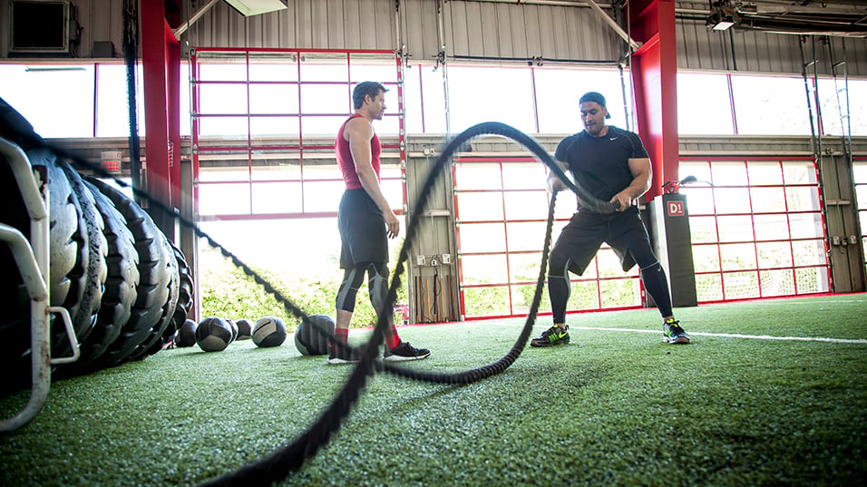 Man using ropes with trainer at D1 Training facility