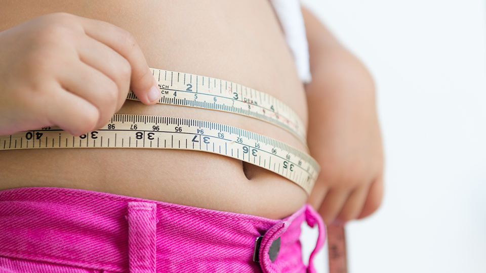 Overweight child measuring tummy