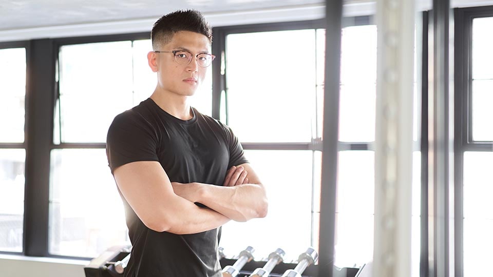 Personal trainer with arms folded in gym
