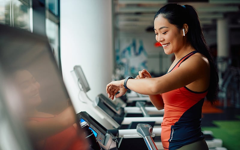 woman on a treadmill using a fitness tracker