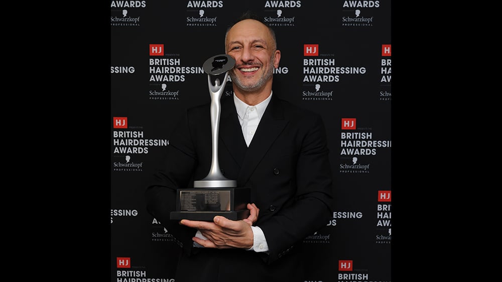 image of Cos Sakkas holding trophy for British Hairdresser of the Year Award