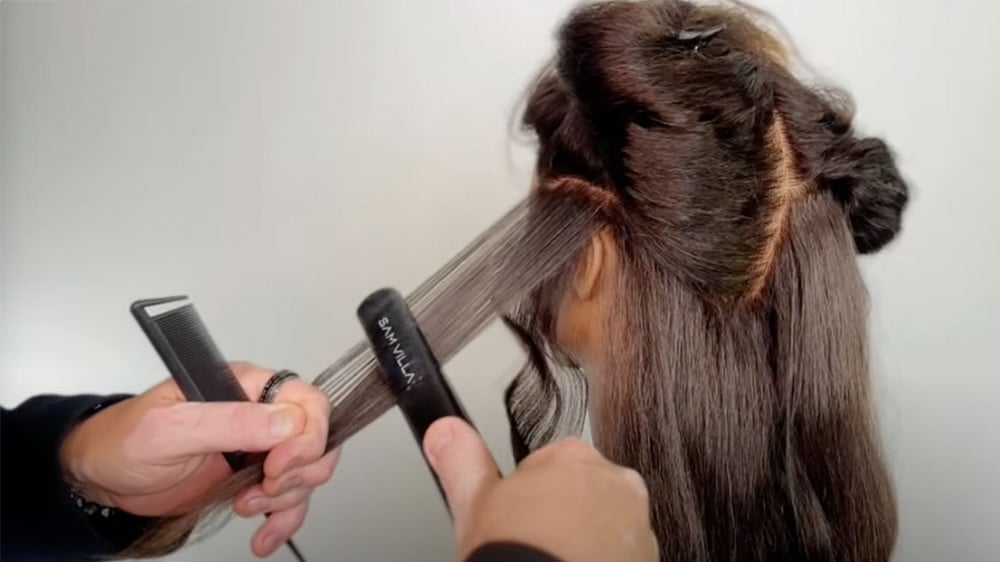 Stylist Roger Molina demonstrates the technique of creating raw waves with a flat iron and comb