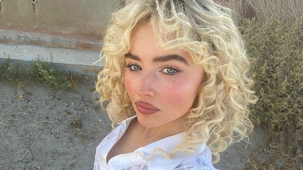 Sabrina Carpenter takes a selfie during the Manchild video shoot