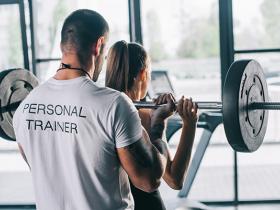 Personal trainer helping a client.